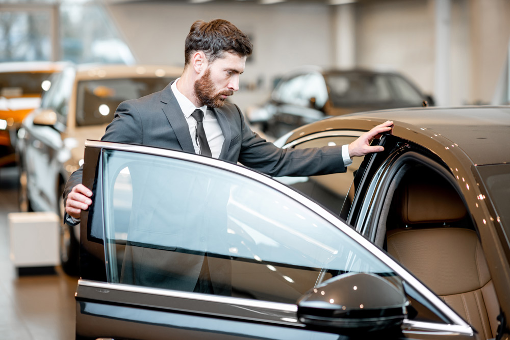 businessman-choosing-car-in-the-showroom-2021-12-09-02-00-23-utc